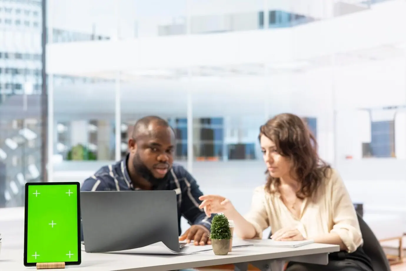 Предприниматель вместе с агентом по недвижимости изучает чертежи возле изолированного дисплея.